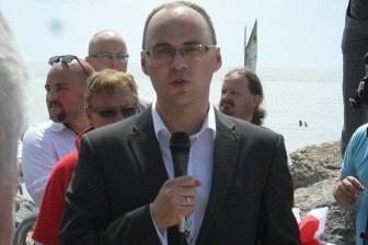 Mężczyzna w garniturze podczas uroczystości odsłonięcia kopca Kaszubów.