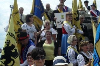 Ludzie z flagami i w strojach regionalnych podczas odsłonięcia kopca Kaszubów.