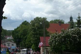 Tłum ludzi na obchodach 800-lecia Żukowa z drzewami i budynkami w tle.