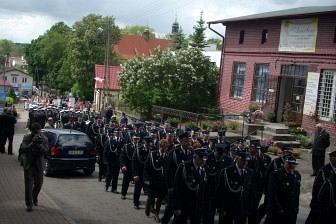 Defilada uczestników w mundurach na ulicy Żukowa podczas uroczystości.