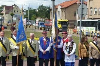 Uczestnicy parady 800-lecia Żukowa w różnych strojach pozują do zdjęcia na ulicy.
