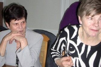 Dwie kobiety siedzą przy stole na zabawie Andrzejkowej.