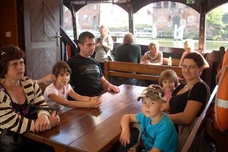 Rodziny odpoczywają przy stole w restauracji podczas wycieczki krajoznawczej w Gdańsku.