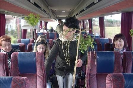 Dzieci w autobusie wracające z Targów Ogrodniczych, jedno z kapeluszem i rośliną.
