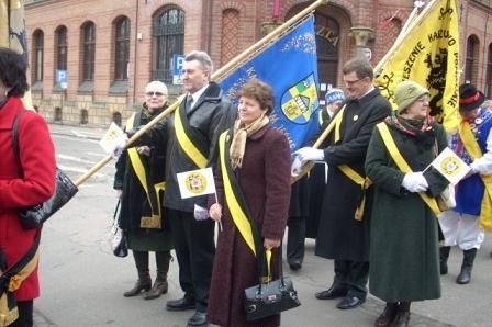 Uczestnicy Dnia Jedności Kaszubów niosący kaszubskie flagi i szarfy.