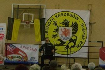 Uczestnicy Dnia Jedności Kaszubów przed plakatami na wydarzeniu.