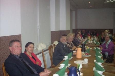 Uczestnicy 5-lecia ZKP O/LINIA zebrani przy stole podczas uroczystego spotkania.