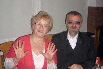 Kobieta i mężczyzna w garniturze siedzący przy stole podczas uroczystości ZKP.
