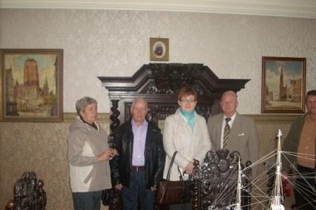 Uczestnicy wycieczki ZKP pozują w eleganckim, historycznym wnętrzu.