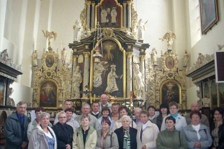 Grupa wycieczkowa ZKP Linia pozuje w kościele przed bogato zdobionym ołtarzem.