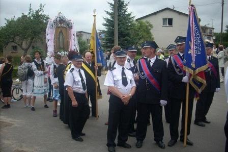 Procesja odpustowa w Sianowie: mężczyźni w mundurach niosą sztandary i figurę.