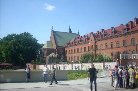 Wawel Królewski z katedrą i turystami w słoneczny dzień.