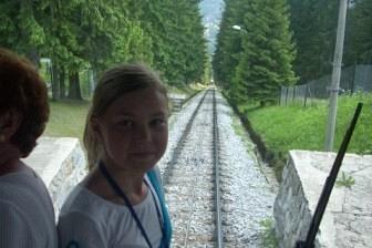 Dziecko z wycieczki ZKP O/Linia patrzy z autokaru na zieloną drogę z drzewami.