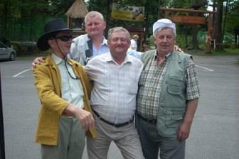 Czterech mężczyzn z wycieczki ZKP O/Linia uśmiecha się do zdjęcia, jeden ściska dłoń.