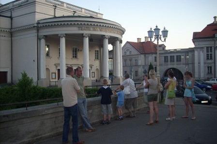 Uczestnicy wycieczki ZKP O/LINIA pod zabytkowym budynkiem z kolumnami w tle.