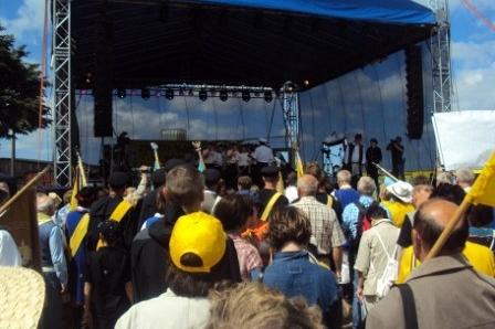Scena z publicznością na Zjeździe Kaszubów w Pucku, wiele osób w żółtych czapkach.