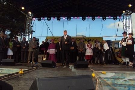 Ludzie na scenie podczas Zjazdu Kaszubów, z ekranem w tle.