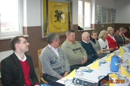 Uczestnicy szkolenia ZKP Linia siedzą przy stole, na ścianie wisi baner.