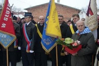 Uczestnicy obchodów niosący sztandary podczas uroczystości.