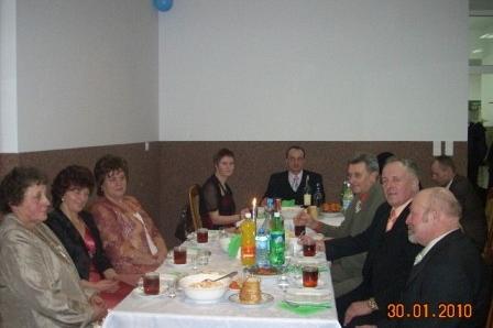 Uczestnicy zabawy karnawałowej ZKP O/LINIA biesiadują przy stole.