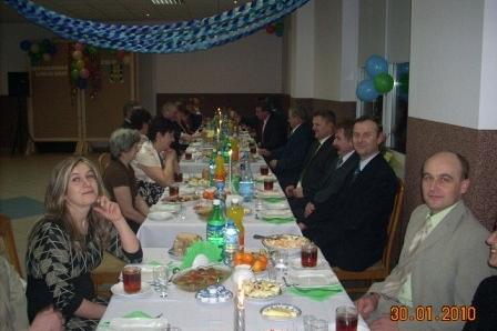 Uczestnicy zabawy karnawałowej ZKP O/Linia siedzą przy udekorowanym stole.