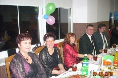 Uczestnicy zabawy karnawałowej siedzą przy stole z balonami.