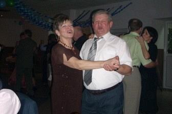Uśmiechnięta para bawi się, tańcząc na karnawałowej zabawie.
