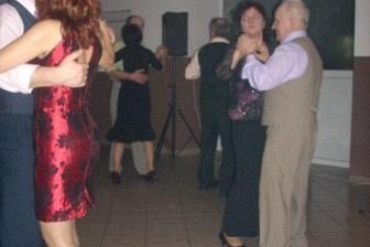 Eleganckie pary wirują w tańcu na zabawie karnawałowej ZKP O/LINIA w jasnej sali.