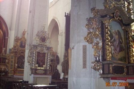 Wnętrze zabytkowego kościoła z bogatymi, złoconymi dekoracjami barokowymi.