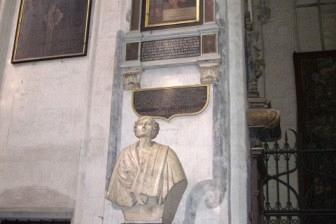 Marmurowe popiersie na postumencie obok pamiątkowych tablic w kościele.