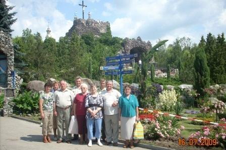 Uczestnicy wycieczki pozują przed licheńskim sanktuarium na tle wzgórza z krzyżem.