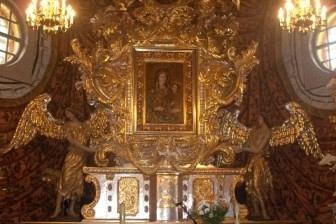 Wnętrze kościoła z majestatycznym, bogato złoconym ołtarzem głównym.