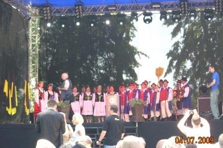 Publiczność ogląda występ orkiestry lub chóru na scenie podczas Zjazdu Kaszubów w Bytowie.