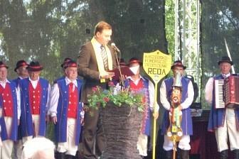 Przemawiający na podium podczas Zjazdu Kaszubów, za nim uczestnicy wydarzenia.