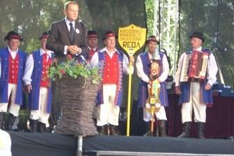 Grupa uczestników Zjazdu Kaszubów w strojach regionalnych na scenie.