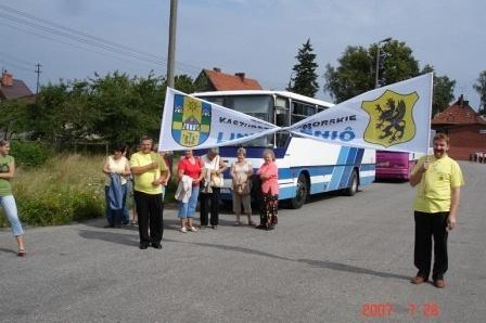 Uczestnicy Zjazdu Kaszubów pozują przed autobusem z banerami.