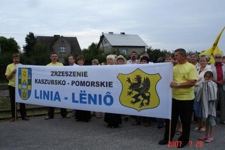 Uczestnicy Zjazdu Kaszubów trzymają baner gminy Linia-Łężyńo z gryfem.