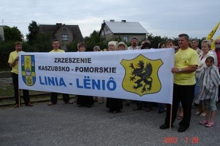 Uczestnicy Zjazdu Kaszubów niosący baner Gminy Linia z herbem gryfa.