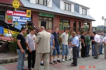 Uczestnicy festynu sportowego na Kaszubach zgromadzeni przed budynkiem.