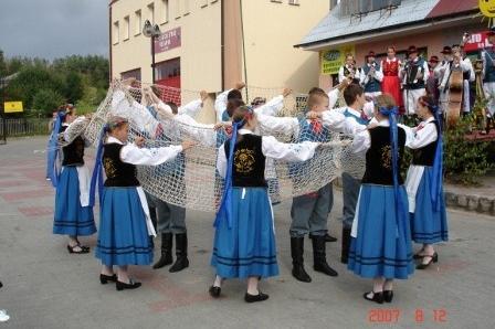 Kaszubski zespół tańczy w ludowych strojach podczas festynu na Kaszubach.