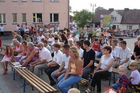 Widzowie festynu sportowego na Kaszubach siedzą na ławkach.