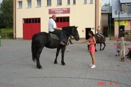 Jazda konna na festynie na Kaszubach, osoba na koniu i dziecko obok.