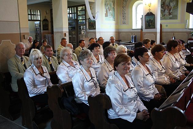Chór festiwalowy PATER NOSTER siedzący w kościele.