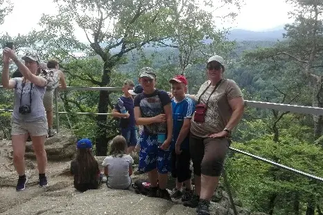 Młodzież z kolonii letniej w Karpaczu uśmiechnięta na górskim szlaku.