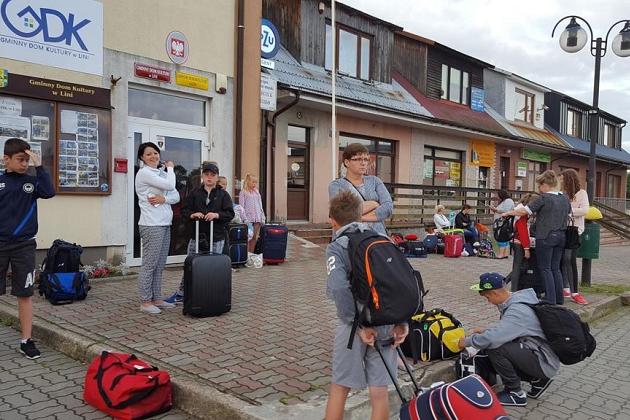 Uczestnicy językowej kolonii z bagażami przed miejscem zakwaterowania.