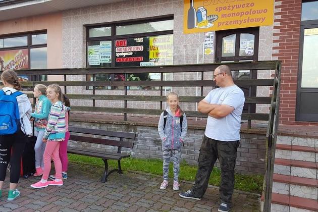 Dzieci i opiekun uczestniczą w letnich zajęciach na kolonii językowej.