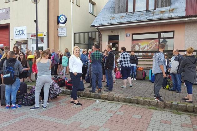 Młodzież z kolonii językowej w Karpaczu przed budynkiem w słoneczny dzień.