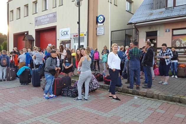 Grupa uczestników kolonii językowej z bagażami przed budynkiem, gotowa do wyjazdu.