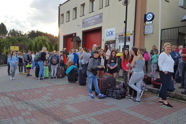 Młodzież z rowerami gromadzi się przed budynkiem podczas kolonii w Karpaczu.