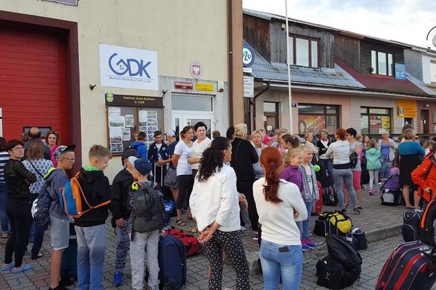 Uczestnicy językowej kolonii letniej w Karpaczu pozują przed budynkami.